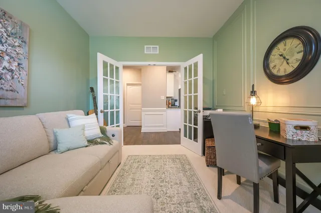 a living room with furniture a clock and a large window