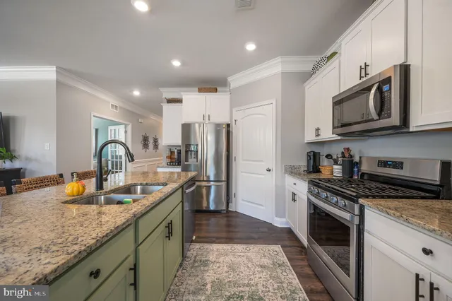 a kitchen with stainless steel appliances granite countertop a sink stove microwave and refrigerator
