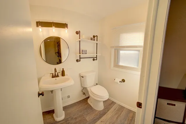 a bathroom with a toilet sink and mirror