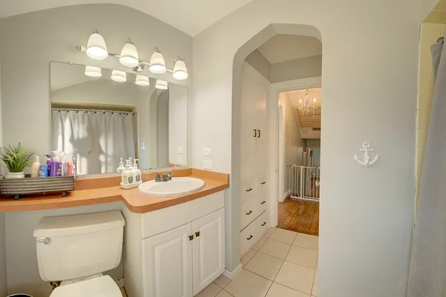 a bathroom with a sink a toilet and a mirror