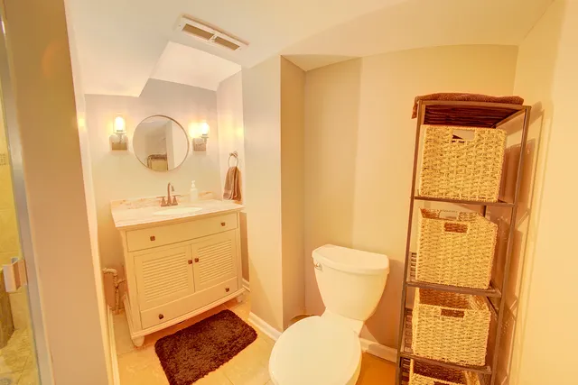 a bathroom with a toilet sink vanity and mirror