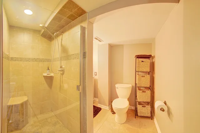 a bathroom with a toilet shower vanity and a sink