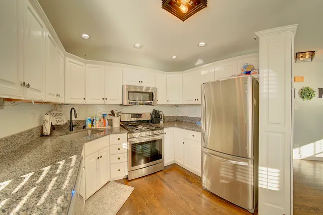 a kitchen with stainless steel appliances a refrigerator sink and microwave