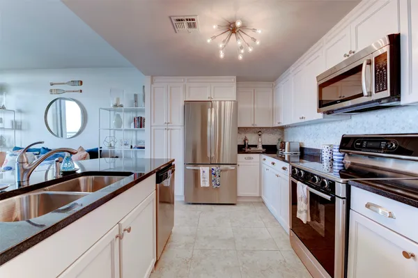 a kitchen with stainless steel appliances granite countertop a sink refrigerator and microwave