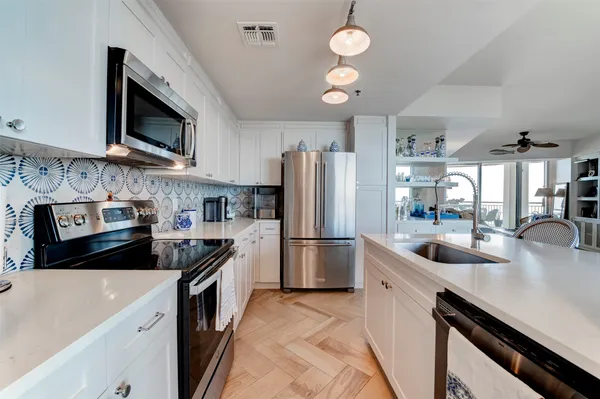 a kitchen with stainless steel appliances granite countertop a sink stove and refrigerator