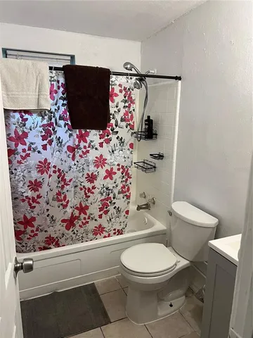 a bathroom with a toilet and a shower curtain