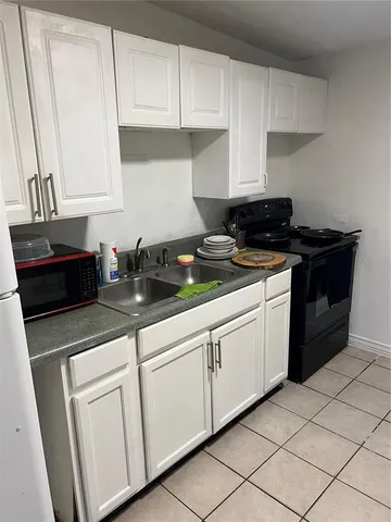 a kitchen with granite countertop white cabinets and white appliances