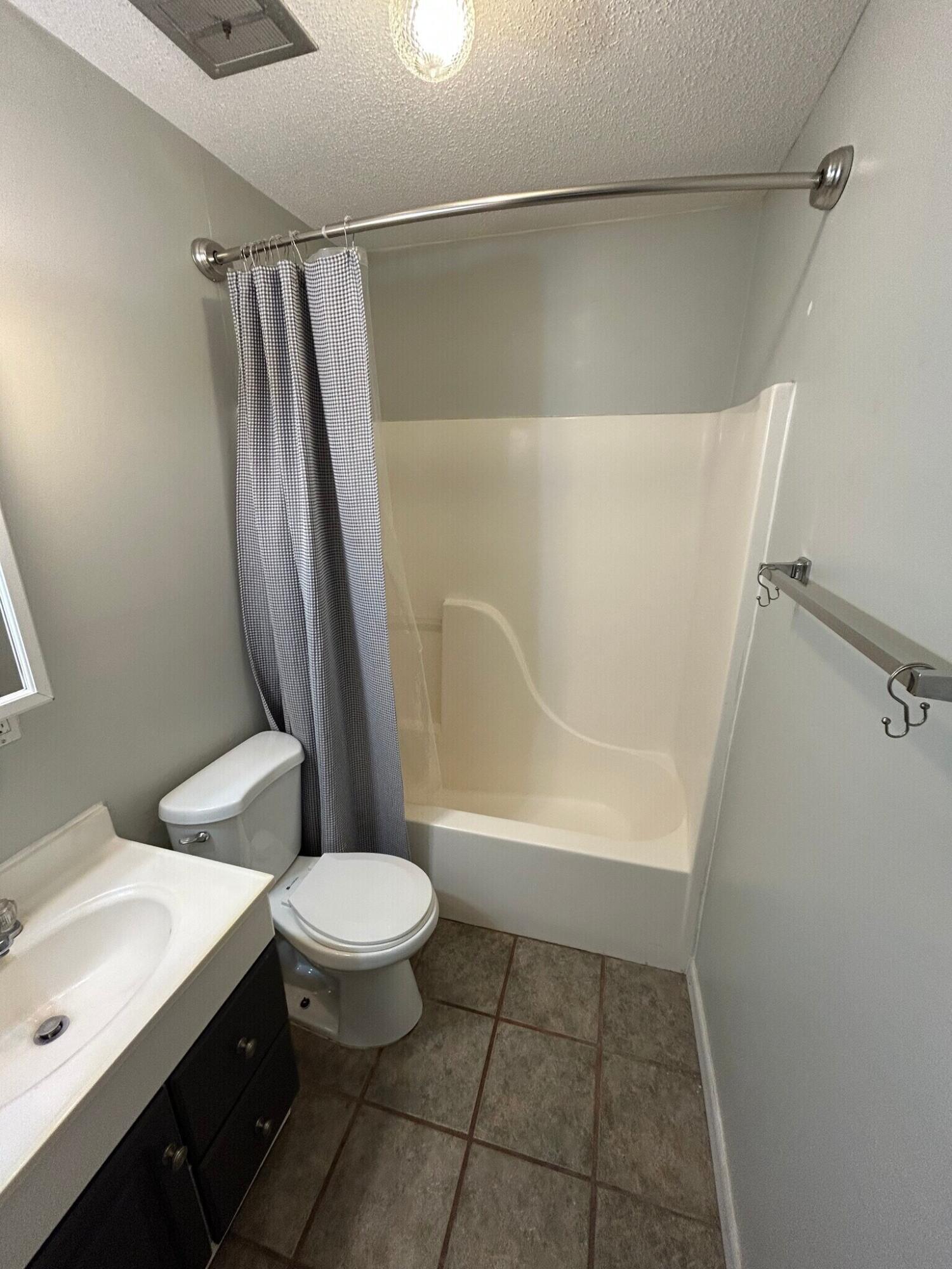 302 Santa Rosa Boulevard, Unit 11 Fort Walton Beach, FL 32548 - Photo 8 of 9 a bathroom with a sink a toilet a mirror and shower