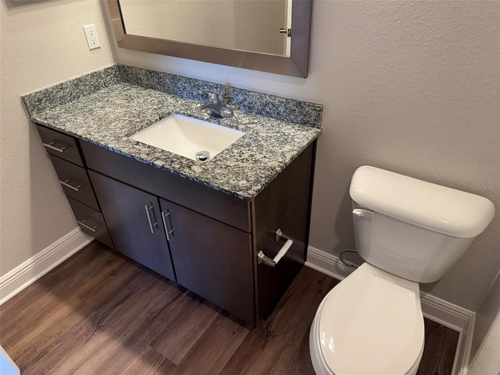 2460 Ann Rou Road, Unit 606 Tavares, FL 32778 - Photo 16 of 18 a bathroom with a granite countertop toilet sink and mirror