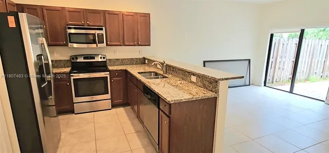 a kitchen with stainless steel appliances granite countertop a stove a microwave and a sink