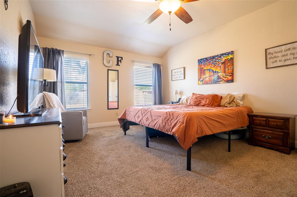 2924 Meandering Way Granbury, TX 76049 - Photo 14 of 40 a spacious bedroom with a bed and wooden floor