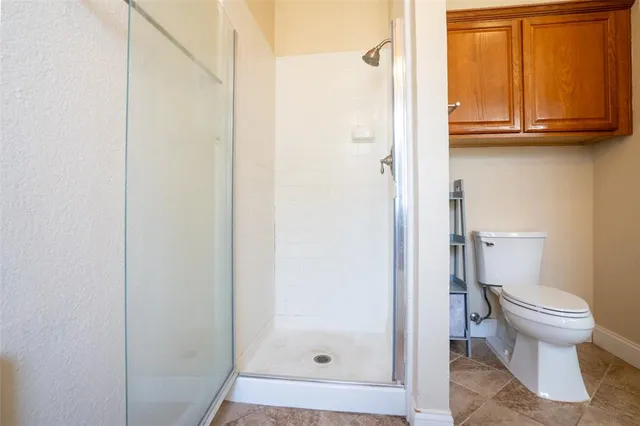 a bathroom with a toilet and a shower