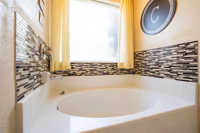 a bathroom with a bathtub and a window