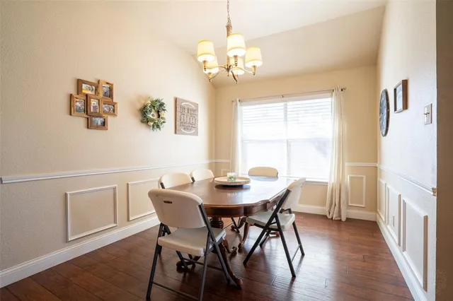 a view of a dining room with furniture wooden floor and a chandelier