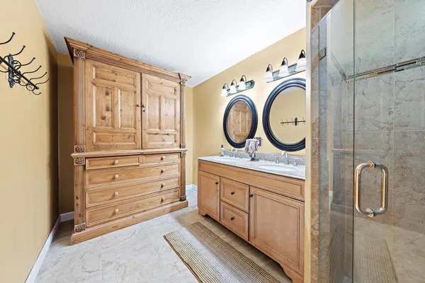 a bathroom with a sink a mirror and shower