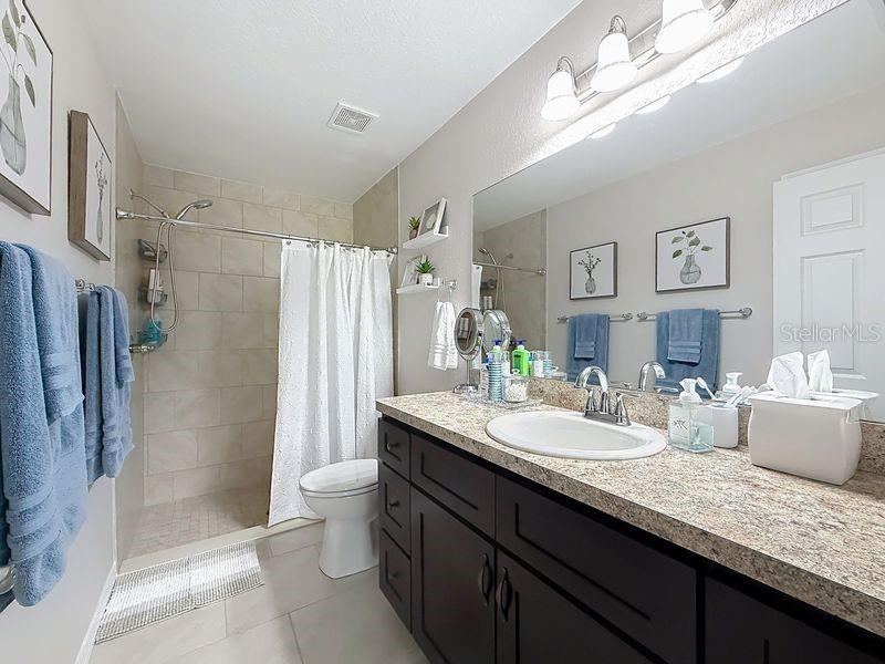 20156 Southwest 83rd Place Dunnellon, FL 34431 - Photo 20 of 28 a bathroom with a granite countertop sink a toilet a mirror a vanity and shower