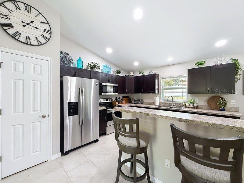 20156 Southwest 83rd Place Dunnellon, FL 34431 - Photo 8 of 28 a kitchen with stainless steel appliances a stove a sink a microwave a refrigerator and cabinets
