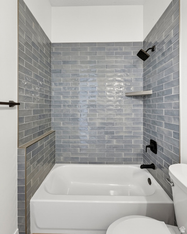 2862 South Mountain Rnch Road Cedar City, UT 84720 - Photo 48 of 64 Bathroom featuring a white tub, matte black shower fixtures, and subway tile surround