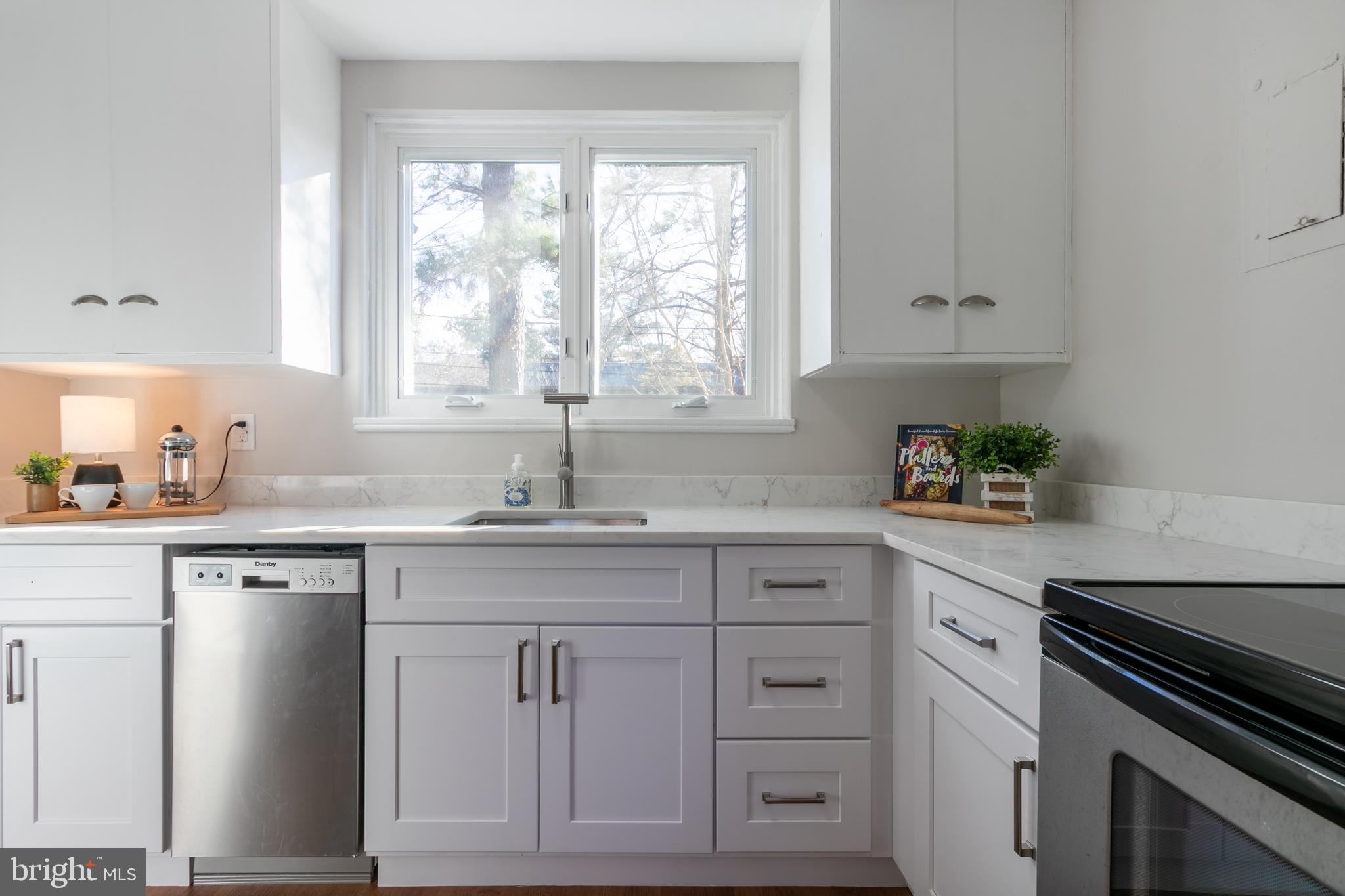 45 Ridge Road Greenbelt, MD 20770 - Photo 13 of 33 a kitchen with white cabinets and a window