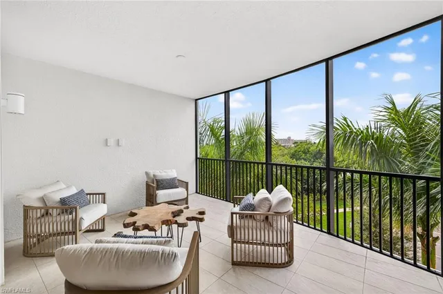 a living room with furniture potted plant a fireplace and a large window