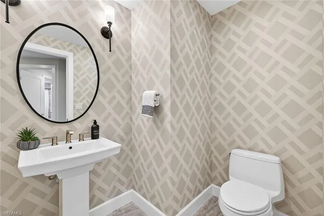 an aerial view of ocean and residential houses with outdoor space