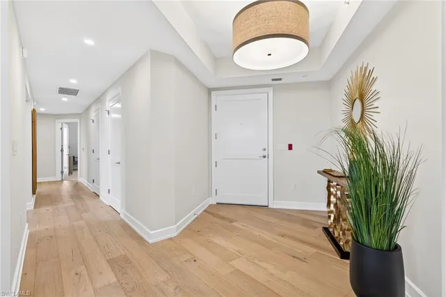 a dining room with furniture large windows and a chandelier