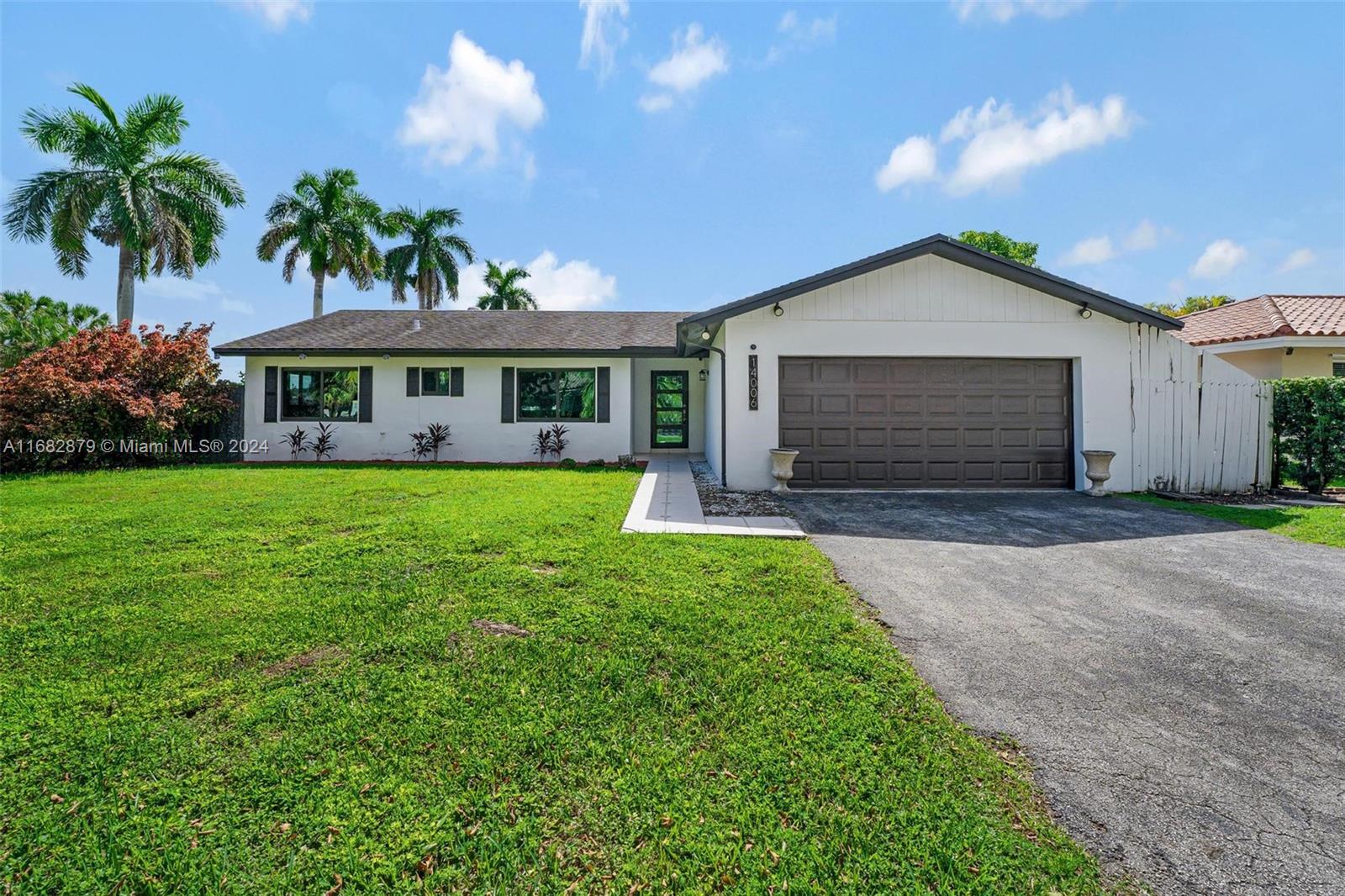 14006 Southwest 48th Terrace Miami, FL 33175 - Photo 2 of 24 a front view of a house with a yard and potted plants