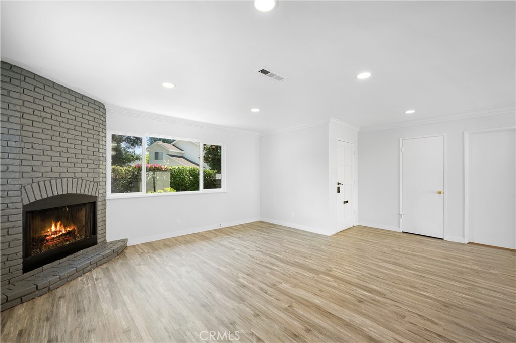 575 Winona Way Pasadena, CA 91103 - Photo 7 of 29 a view of an empty room with wooden floor fireplace and a window