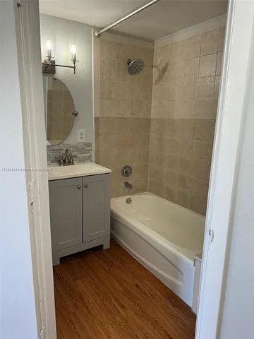 a bathroom with a tub a sink and mirror