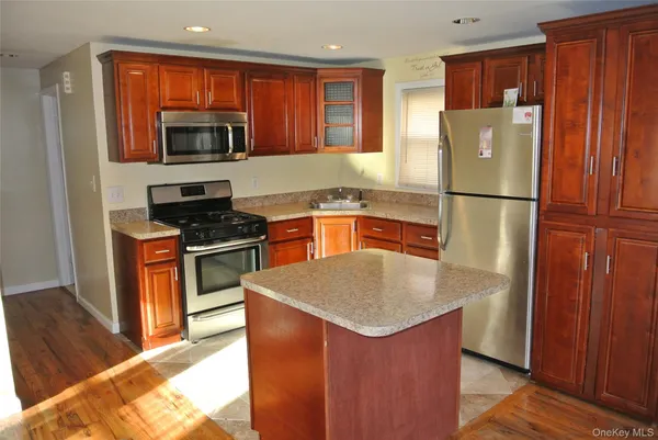 a kitchen with stainless steel appliances granite countertop a refrigerator a stove top oven a sink and dishwasher