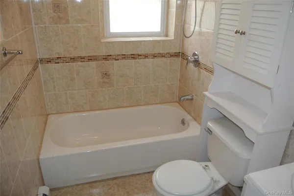a white bath tub sitting next to a toilet