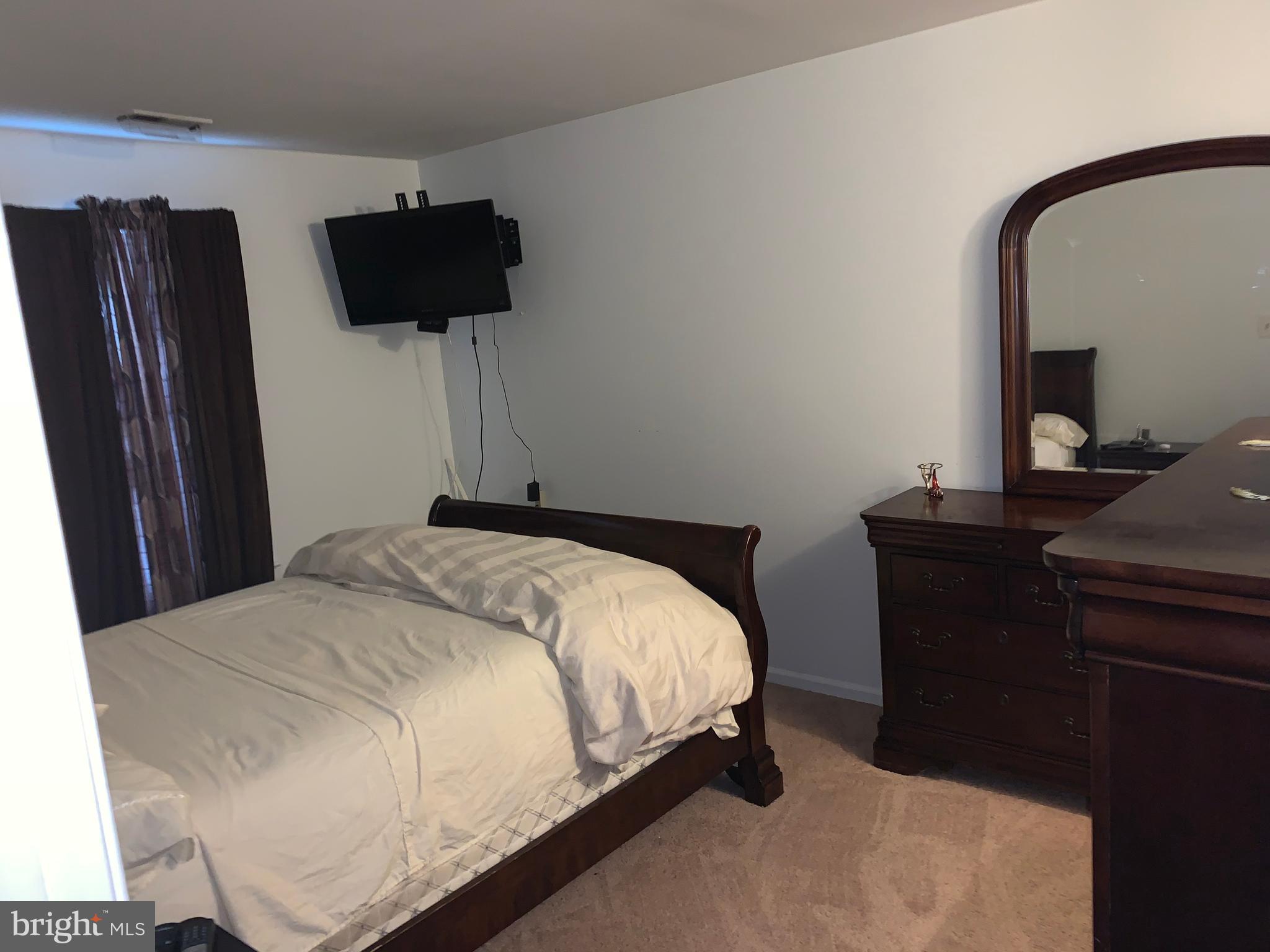 1609 Huntingdon Mews Clementon, NJ 08021 - Photo 11 of 15 a bedroom with a bed and a flat tv screen on a dresser