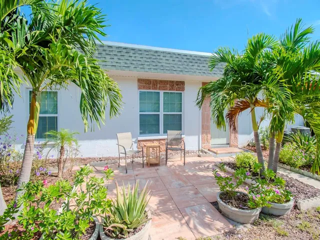 a view of a patio with table and chairs and potted plants
