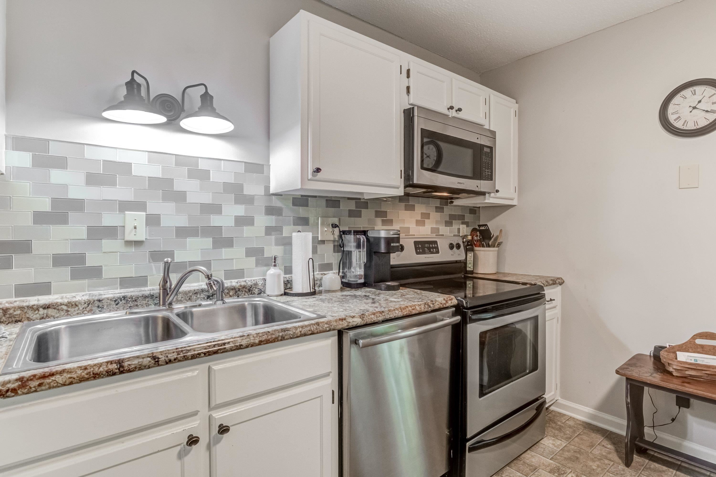705 Tan Tara Square Raleigh, NC 27615 - Photo 17 of 31 a kitchen with stainless steel appliances granite countertop a sink stove top oven and microwave