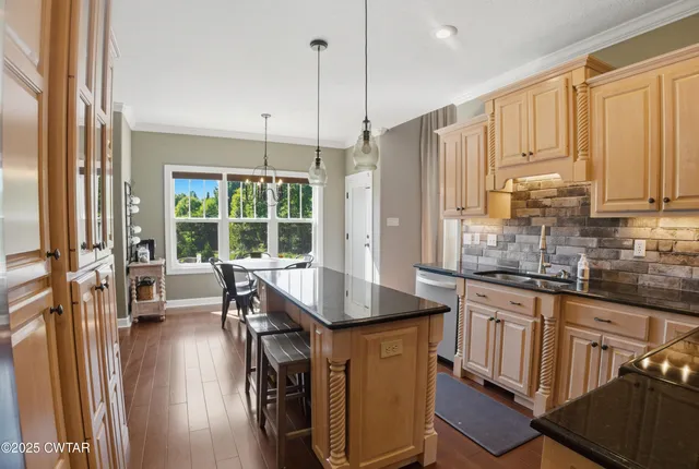 a kitchen with stainless steel appliances granite countertop a stove a sink and a refrigerator with wooden floor