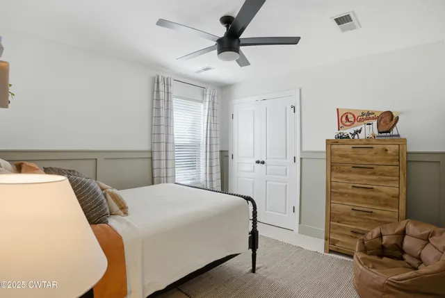a bedroom with a bed and a ceiling fan