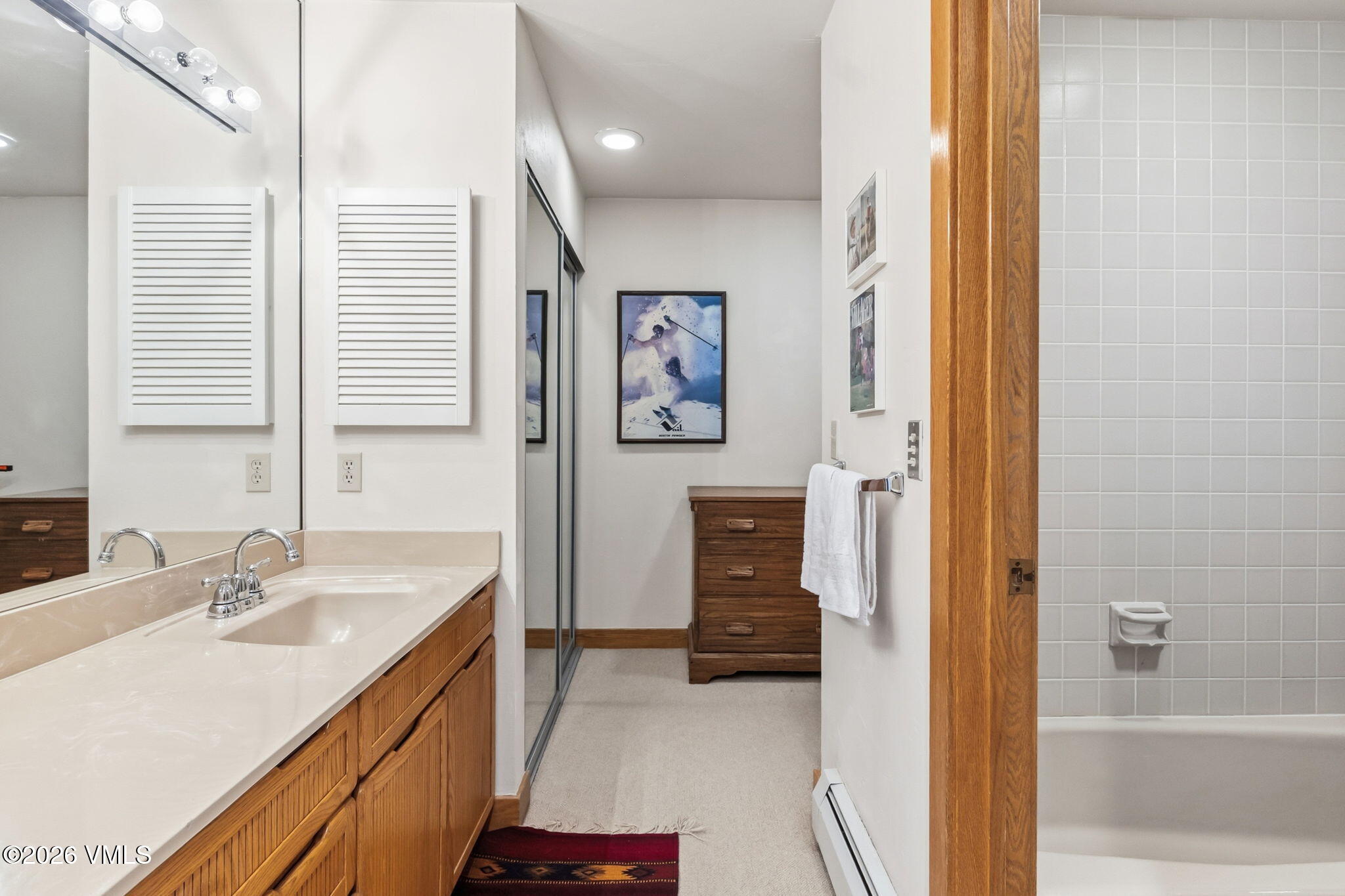 1460 Ridge Lane, Unit D Vail, CO 81657 - Photo 10 of 18 a en suite bathroom with a sink a mirror and a bathtub