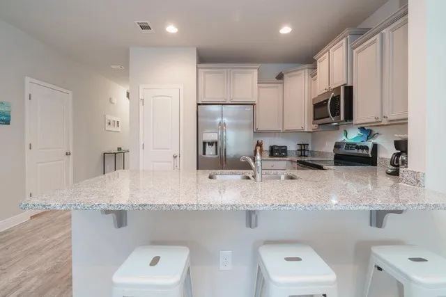 a kitchen with stainless steel appliances granite countertop a sink refrigerator and microwave