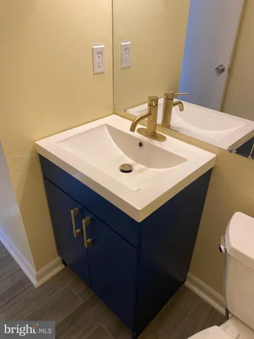 a bathroom with a sink vanity and a toilet