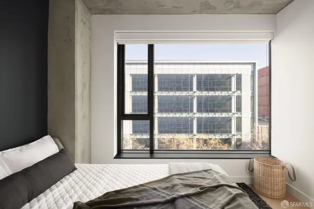 a bedroom with a bed and a large window