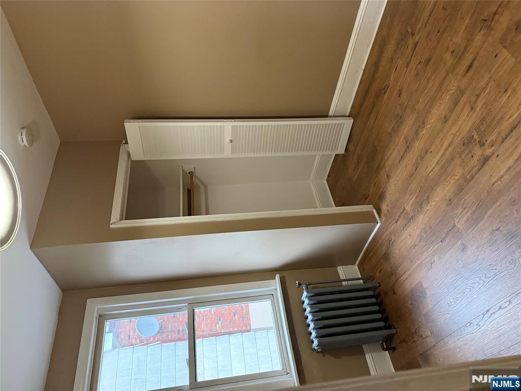 439 Cliff Street, Unit 2 Fairview, NJ 07022 - Photo 6 of 12 an empty room with wooden floor and windows