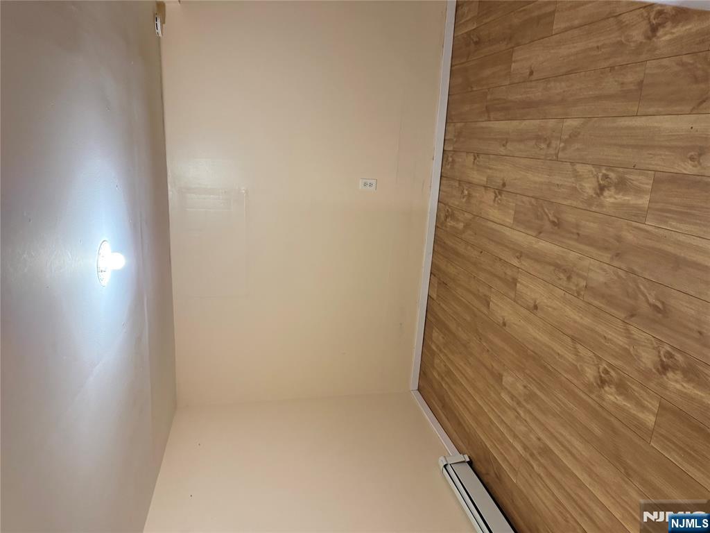 439 Cliff Street, Unit 2 Fairview, NJ 07022 - Photo 9 of 12 an empty room with wooden floor and windows