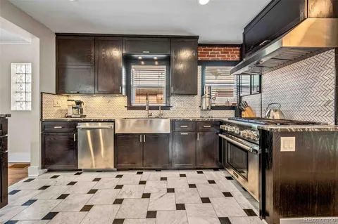 a kitchen with stainless steel appliances granite countertop a sink stove and granite counter tops