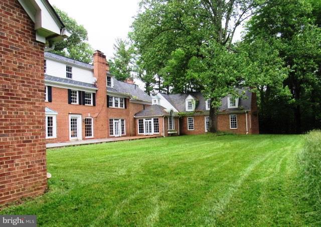 9207 Belmart Road Potomac, MD 20854 - Photo 2 of 13 a front view of a house with a garden and trees
