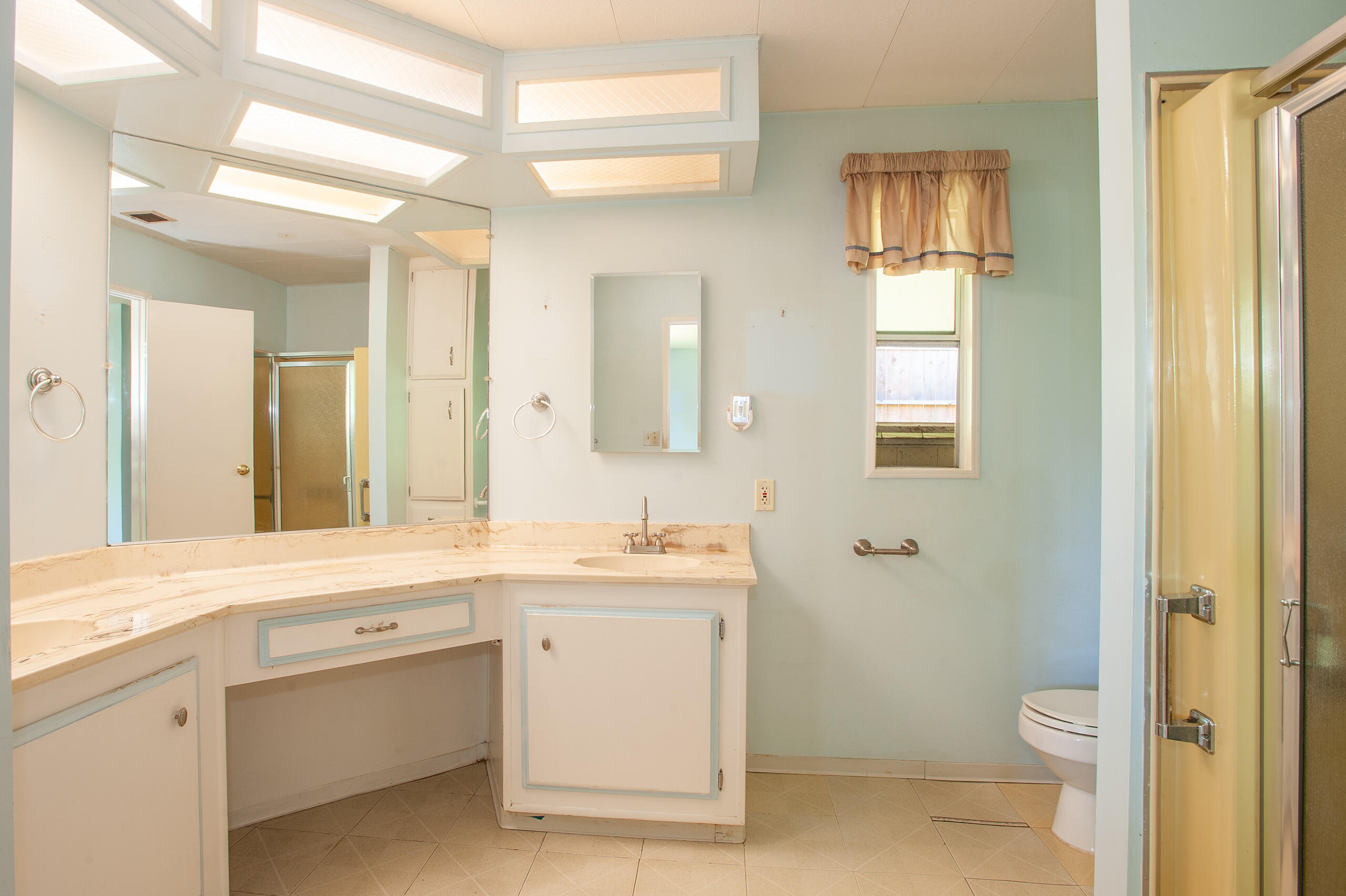 6180 Via Real, Unit 29 Carpinteria, CA 93013 - Photo 15 of 19 a spacious bathroom with a granite countertop sink a toilet and a mirror