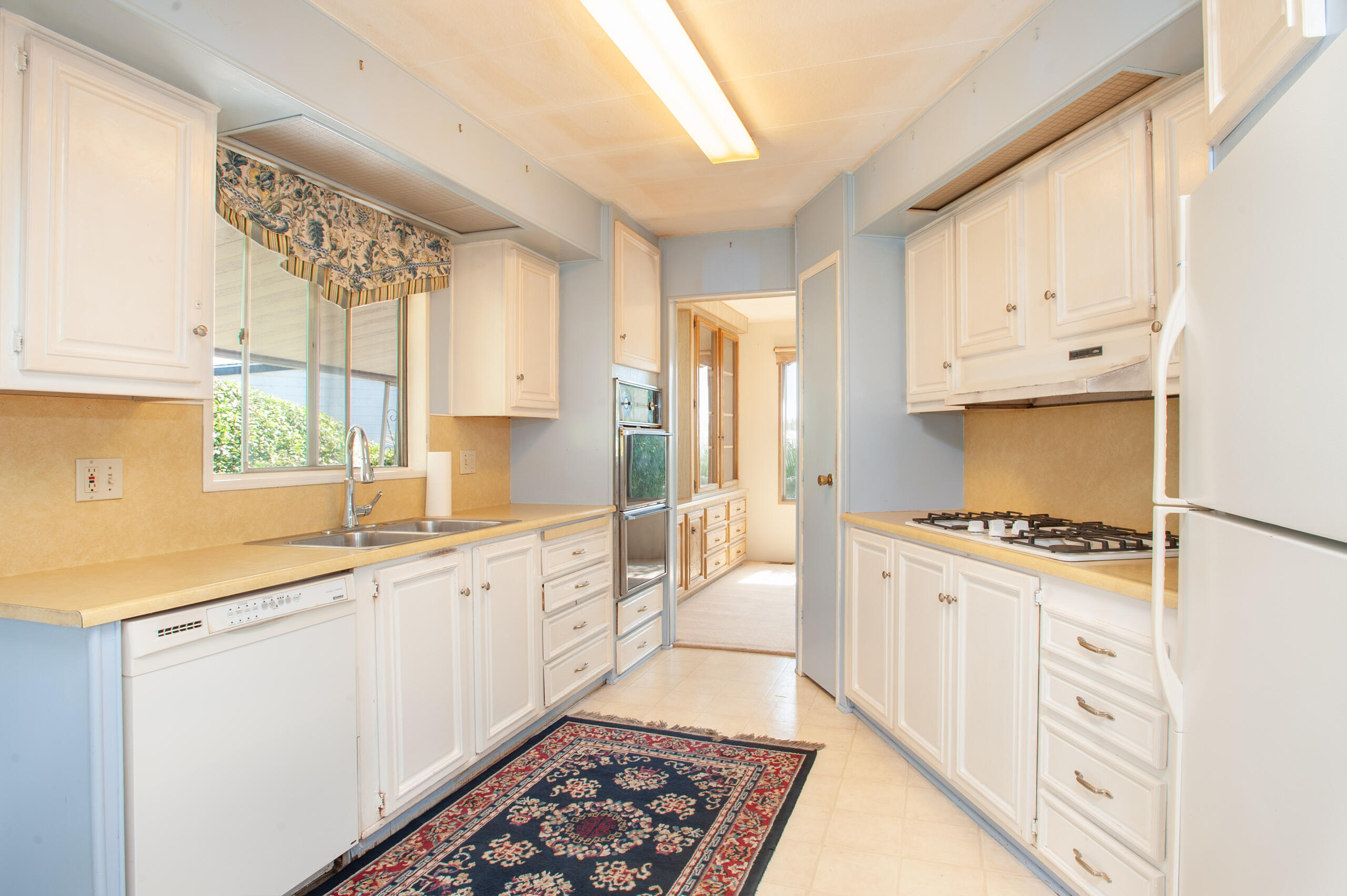 6180 Via Real, Unit 29 Carpinteria, CA 93013 - Photo 9 of 19 a kitchen with granite countertop a sink stove and cabinets