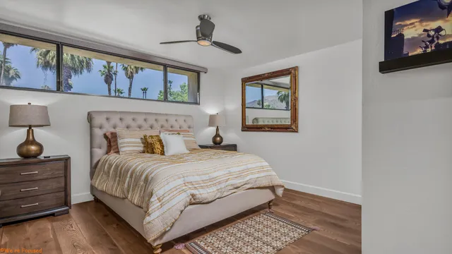 a bedroom with a bed and painting on the wall