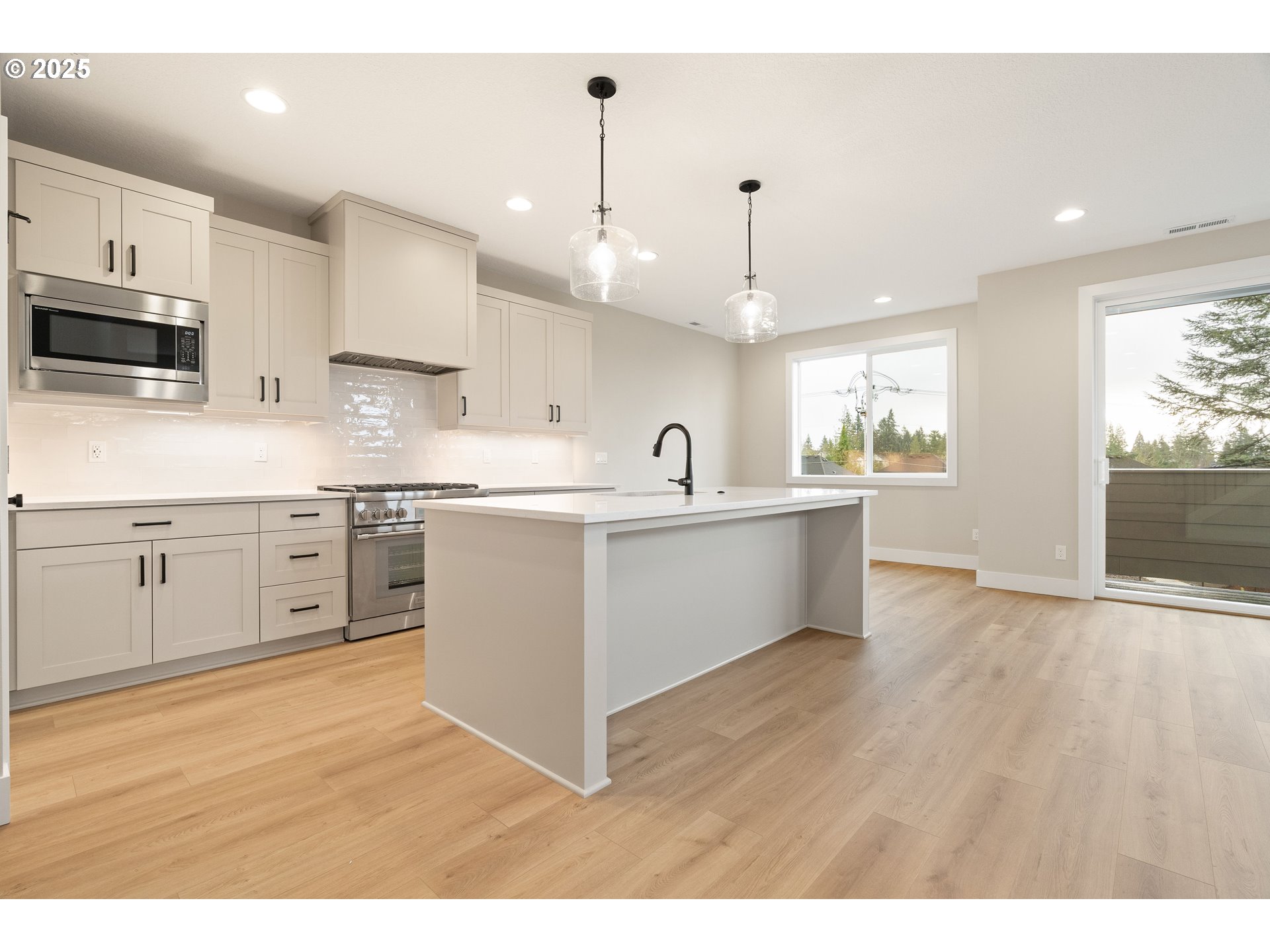 11486 Northwest Elise Lane Portland, OR 97229 - Photo 16 of 48 a open kitchen with kitchen island a sink stainless steel appliances and cabinets