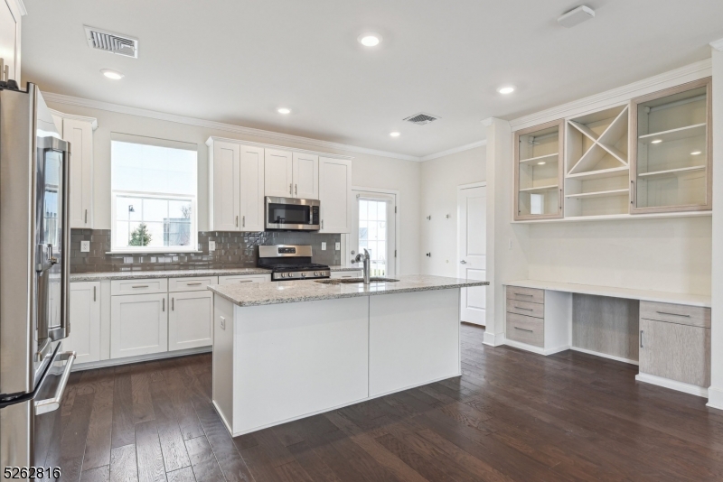 12 Gerhard Place Morristown, NJ 07960 - Photo 2 of 14 a kitchen with stainless steel appliances granite countertop a stove top oven a sink and white cabinets with wooden floor