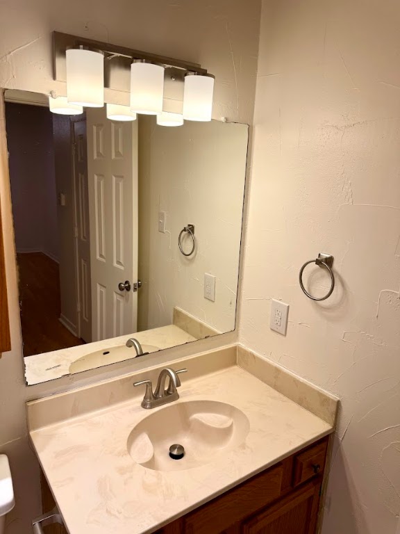 915 West 23rd Street, Unit 108 Austin, TX 78705 - Photo 13 of 15 Half bathroom featuring vanity and a textured wall